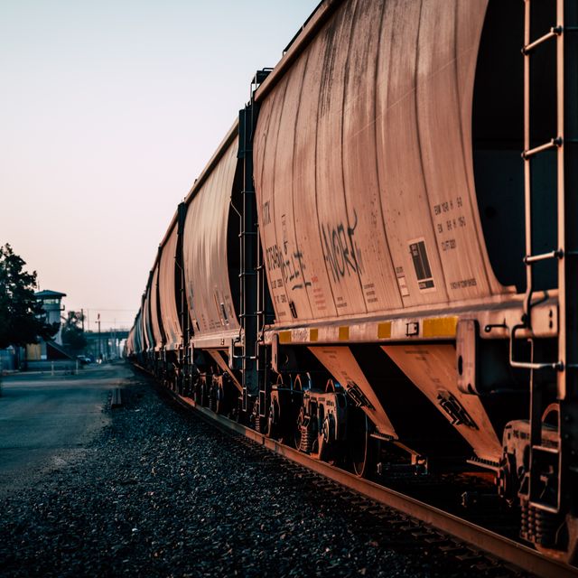 Rail hopper cars on a track at dusk